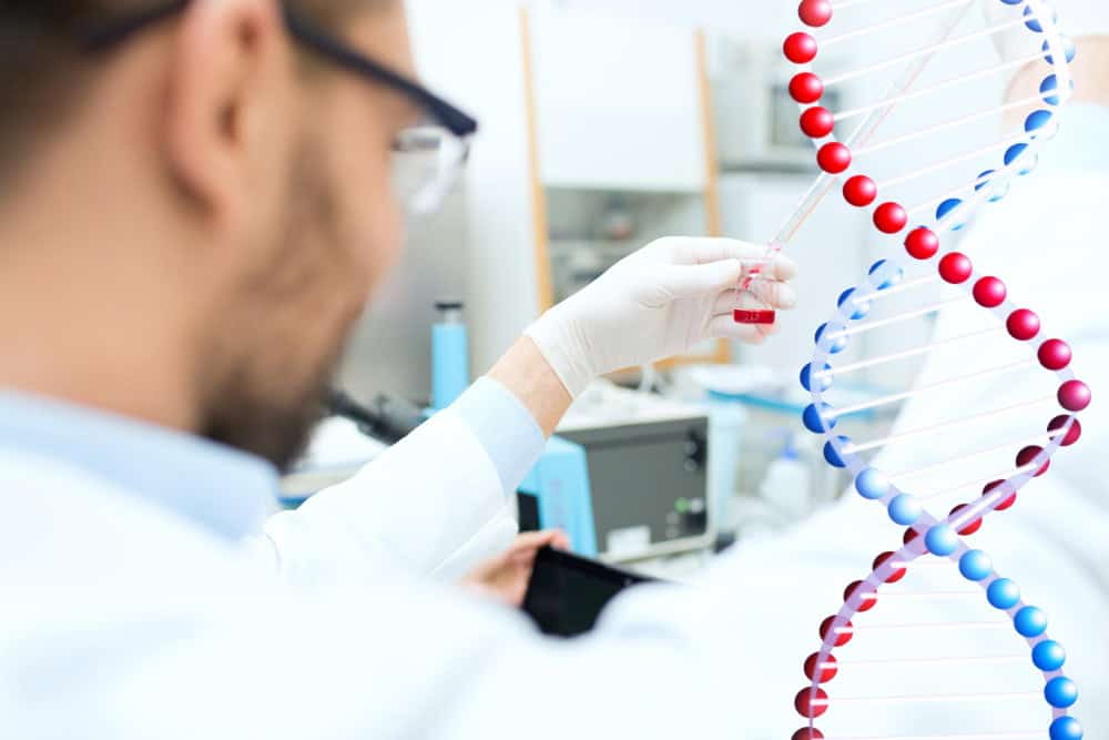 Scientist analyzing DNA strands for male fertility testing in IVF.